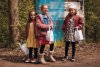 drie kinderen met cadeautasjes in handen aan de ingang van de activiteit