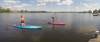 een jongen en meisje aan het suppen op het open water