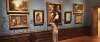 meisje staat voor blauwe muur met schilderijen in kunsthistorisch museum