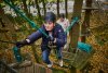 twee meisjes met helm onderweg in klimbos