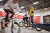 jongen en meisje staand op BMW fiets, kijkend naar andere BMXer