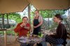 Foto van etende mensen aan tafel in de kruidentuin