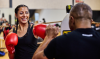 Vrouw staat in de boksring met haar trainer