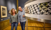 Man en vrouw bekijken kunst in Escher in het Paleis