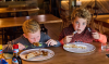 Twee jongens eten een pannenkoek