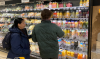 Man en vrouw in de supermarkt voor het schap met sap