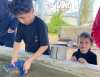 Kindje zeeft steentjes in een bak met water